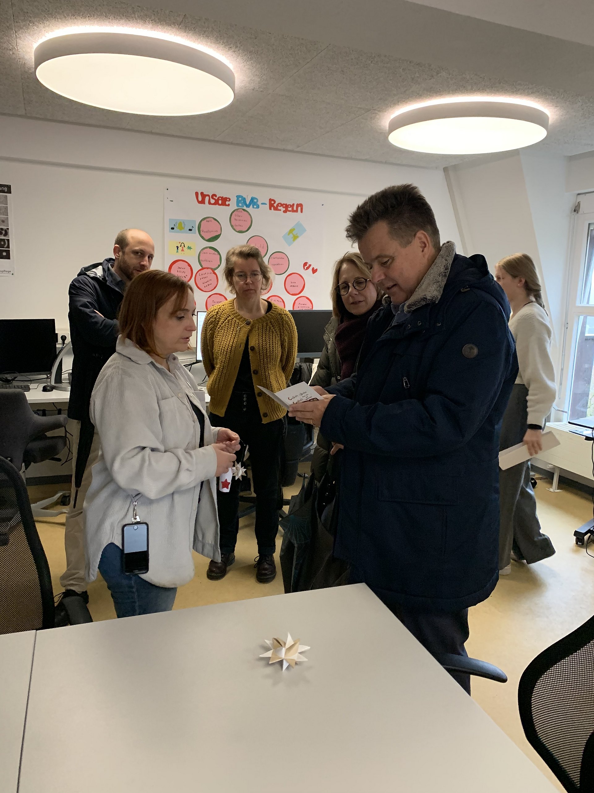 Eine Schülerin unterhält sich mit Jürgen Dusel in einem Klassenzimmer des Betty-Hirsch-Schulzentrum