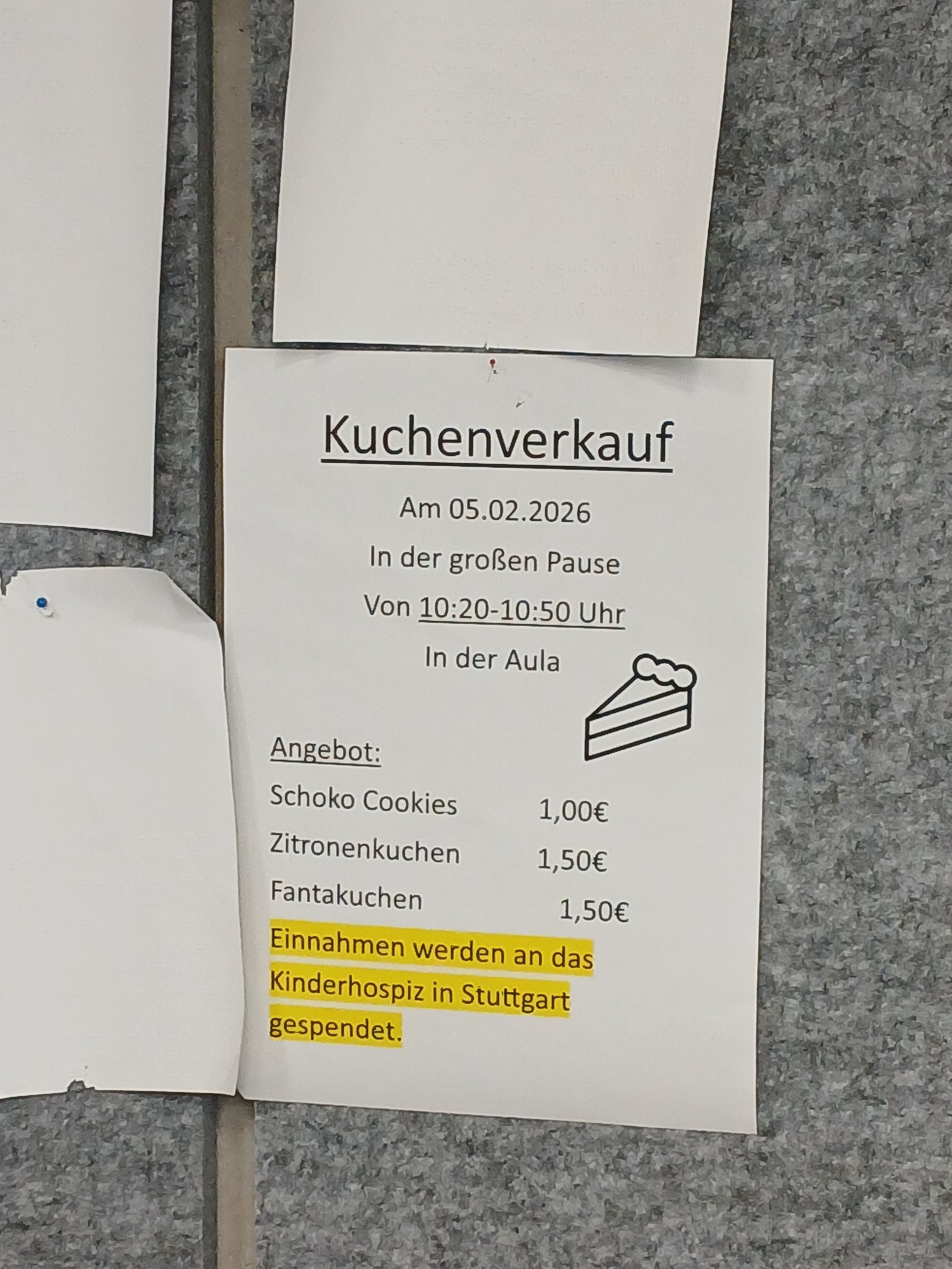 An einer Pinwand hängt ein Blatt papier. Darauf sind Kuchen und ihre Preise aufgelistet. Darunter steht dass der erlös des Kuchenverkaufs an das Kinderhospiz in Stuttgart geht