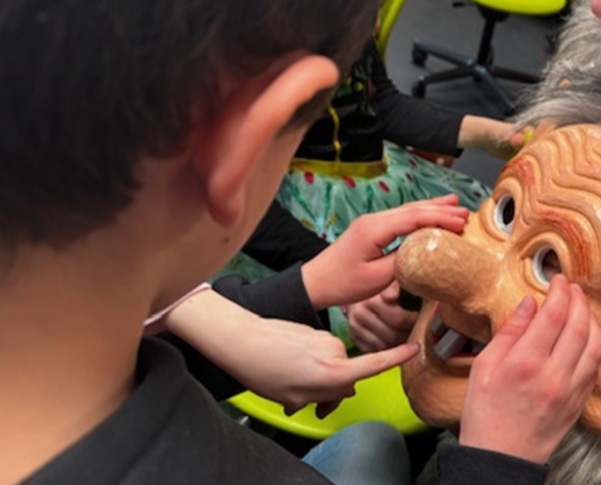 Ein Schüler betastet eine Karnevalsmaske